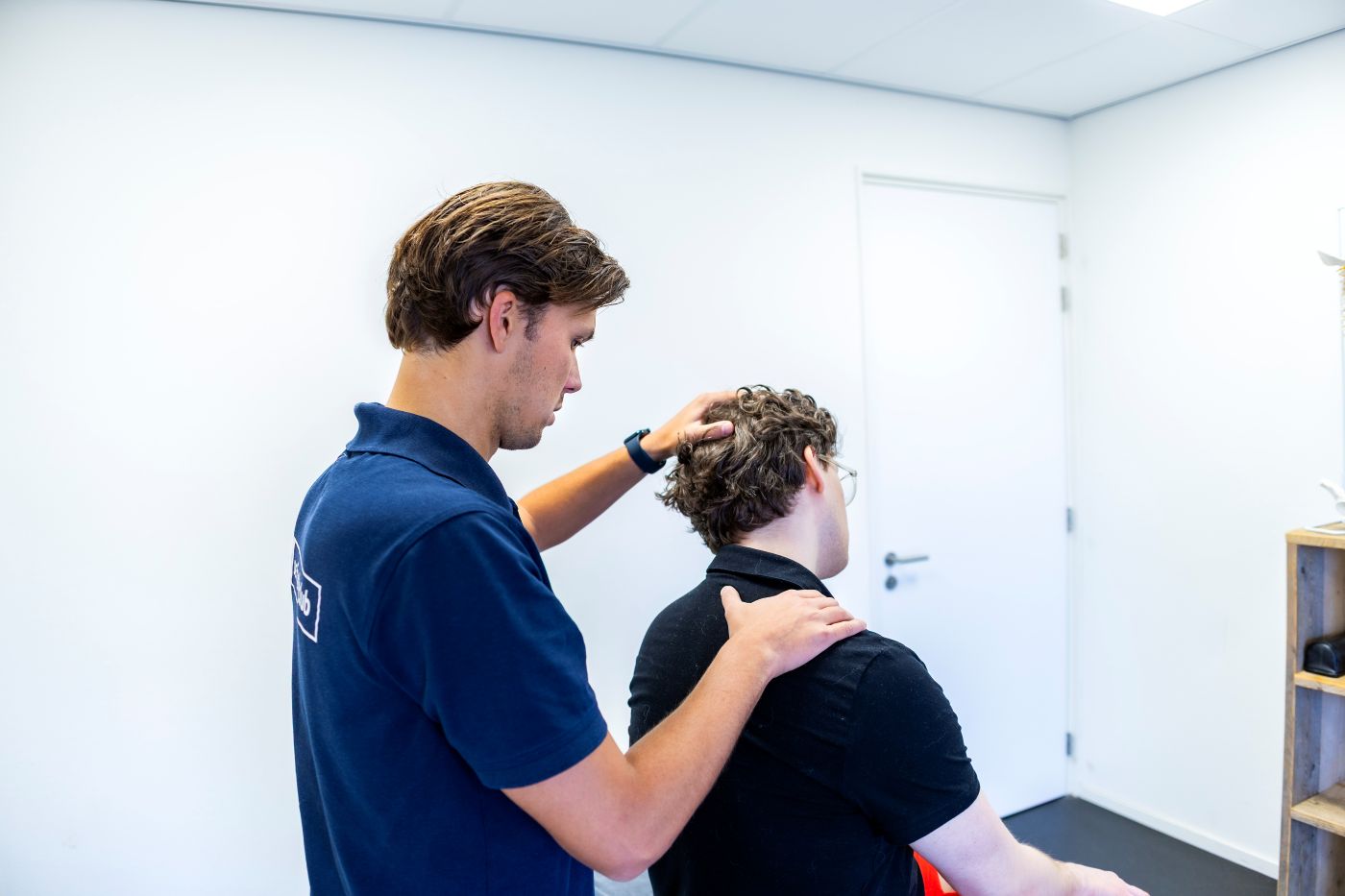 Fysiotherapeut behandelt nekpijn bij patiënt in het Sport & Knie Expertise Centrum Mierlo
